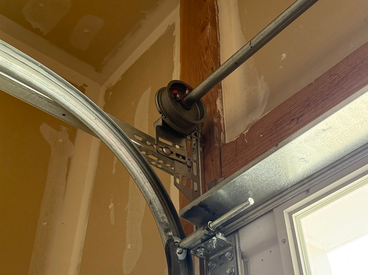 Torsion spring drum, cable and track hardware inside a garage